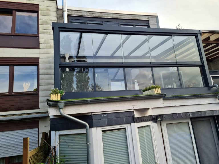 Verglaster Balkon mit anthrazitfarbenem Aluminiumrahmen an einem Reihenhaus