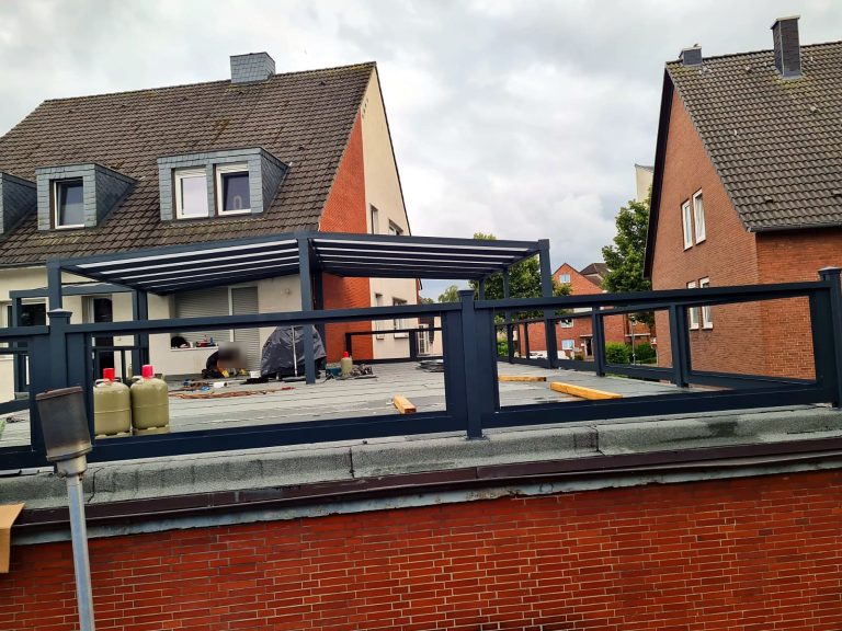 Gestell einer Terrassenüberdachung mit Aluminium-Geländer auf einer Dachterrasse