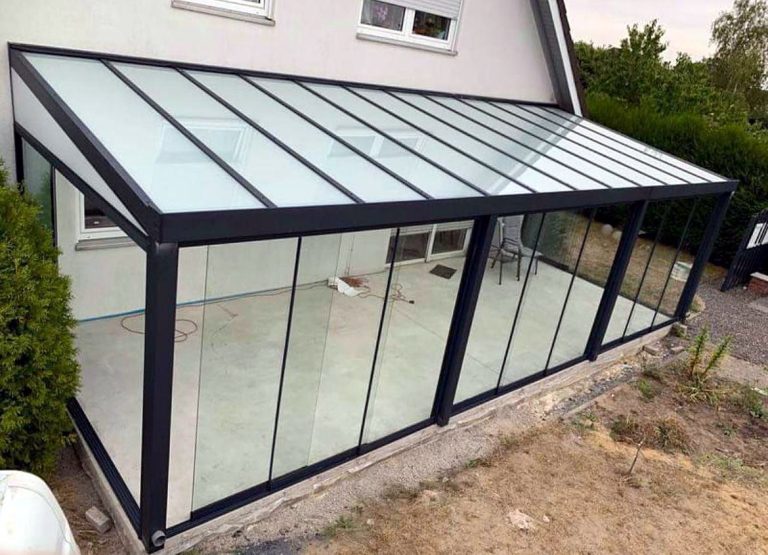Glas-Terrassenraum mit Glasdach und Glasschiebewänden an einem Einfamilienhaus