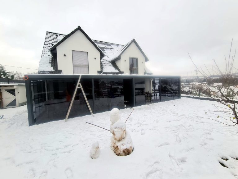 Fertiger Glas-Terrassenraum an einem Einfamilienhaus im Schnee